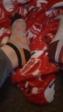 Tiny feet in mix match socks rubbing blanket