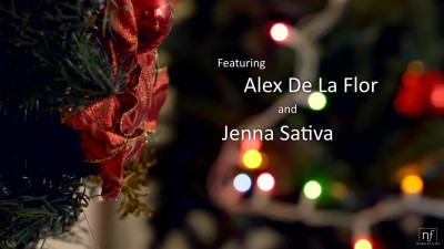 Jenna Sativa and Alex De La Flor on a grey sofa in a Christmas lesbian scene together