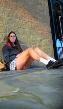 Schoolgirl sitting on the floor with her very short skirt showing her panties